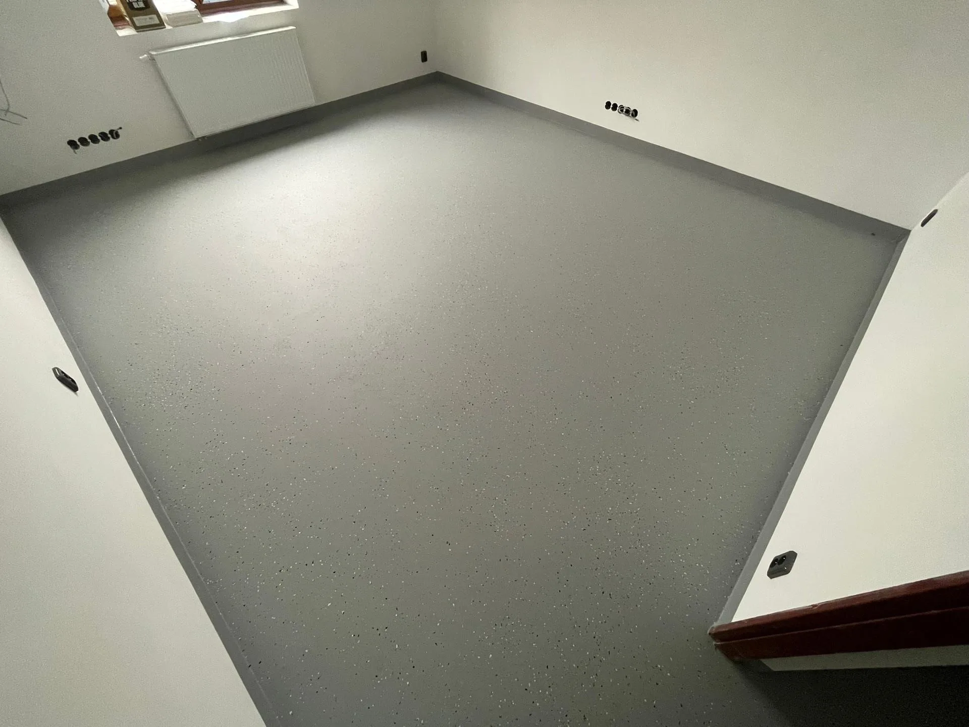 Detail hladké šedé polyuretanové podlahy v interiéru